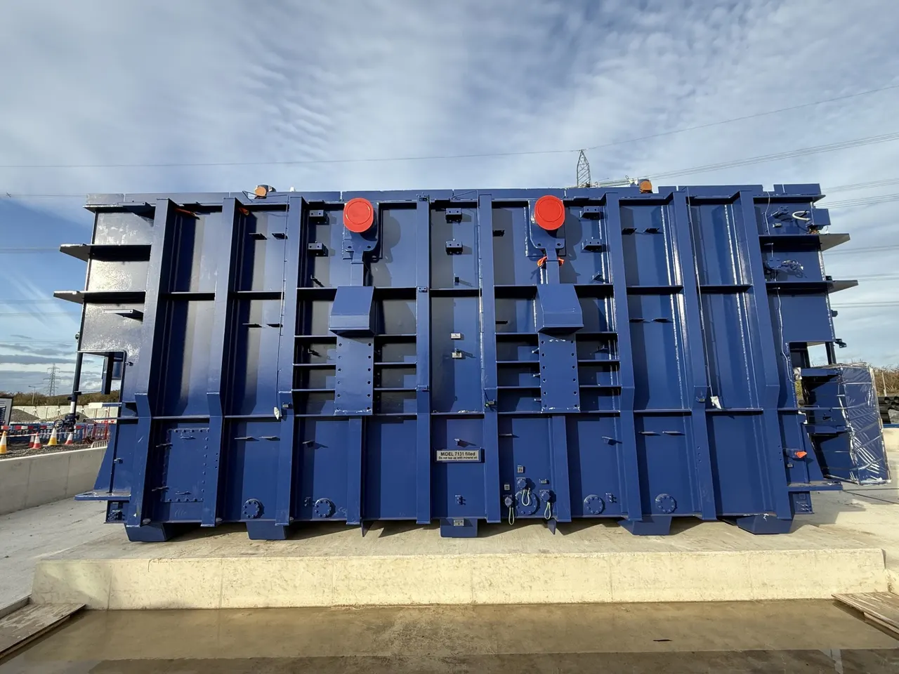 Blue super grid transformer standing in its final position on a concrete plinth.