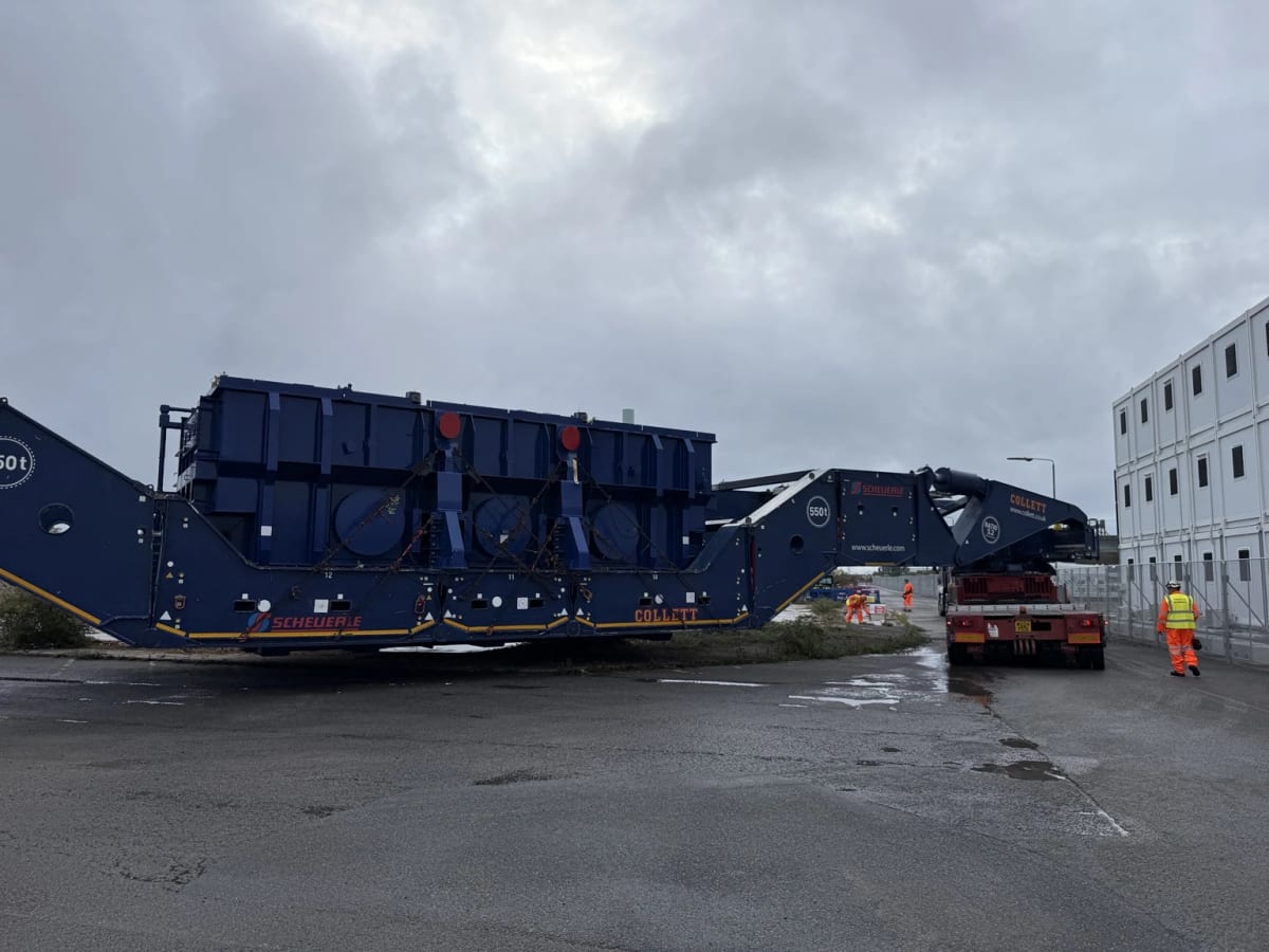 A super grid transformer on a girder bridge transport system being moved across site.